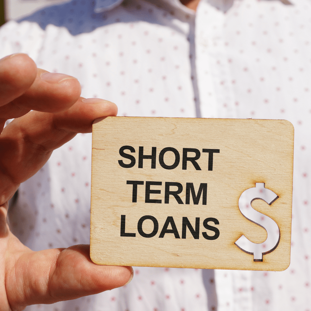 A person holding up a sign that says " short term loans ".